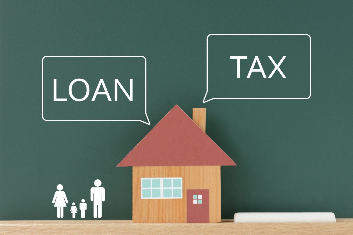ローンと税金に関するテキストが書かれた家の模型と家族のイラスト