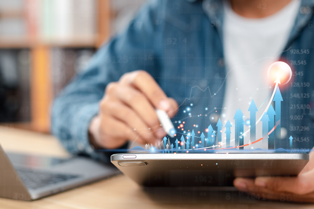 タブレット上に描かれた上昇するグラフと矢印のイラスト。