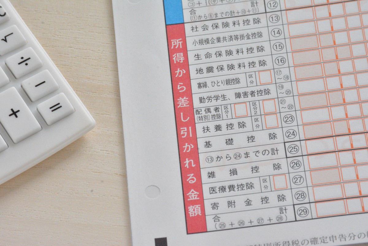 所得税の申告用紙と電卓、所得控除に関連するイメージ