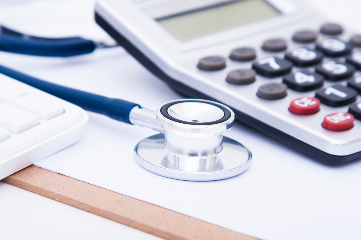 聴診器と電卓が並んだイメージ、医療費や健康管理に関連するコンセプト