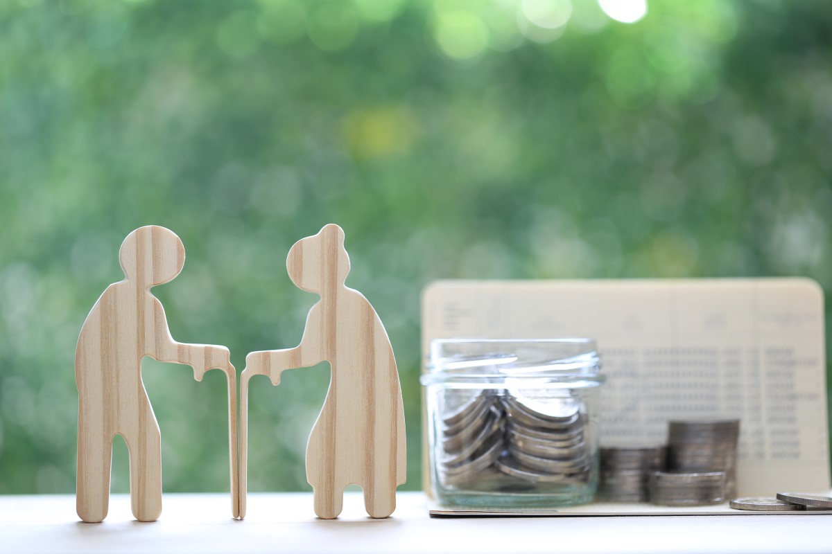 木製の老人カップルのシルエットとコインの入ったガラス瓶が並ぶ光景。