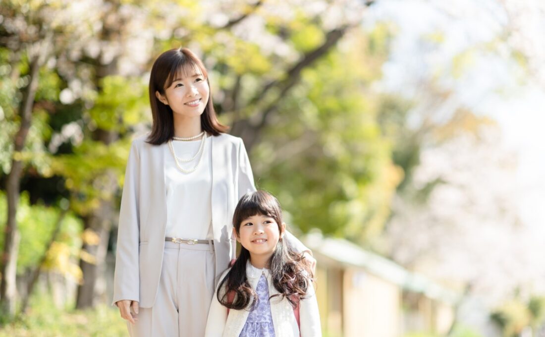 春の公園で微笑む母親と娘。
