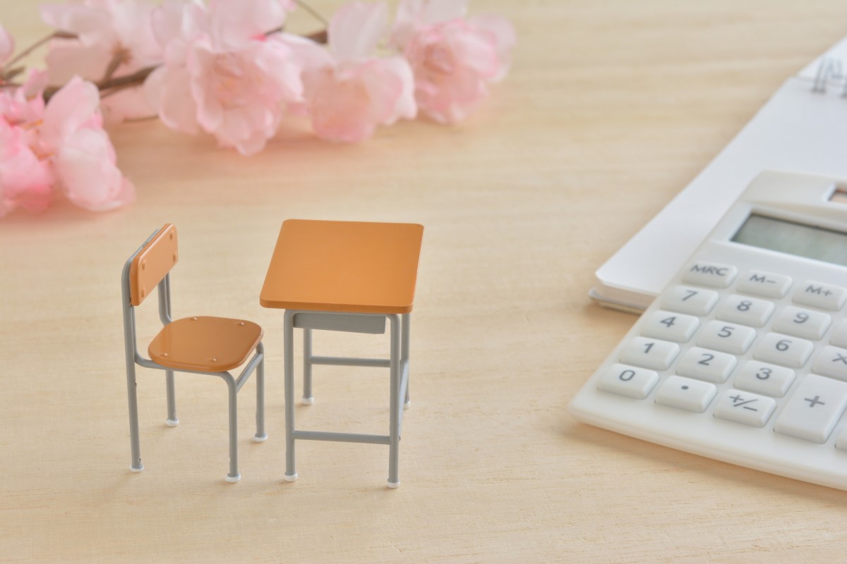 桜の花とミニチュアの学習机、電卓が並ぶ光景。