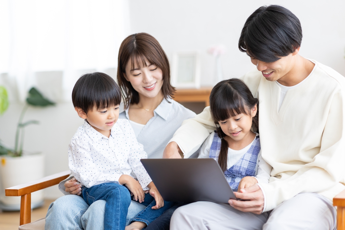 家族全員でパソコンを見ながら過ごす笑顔の家族