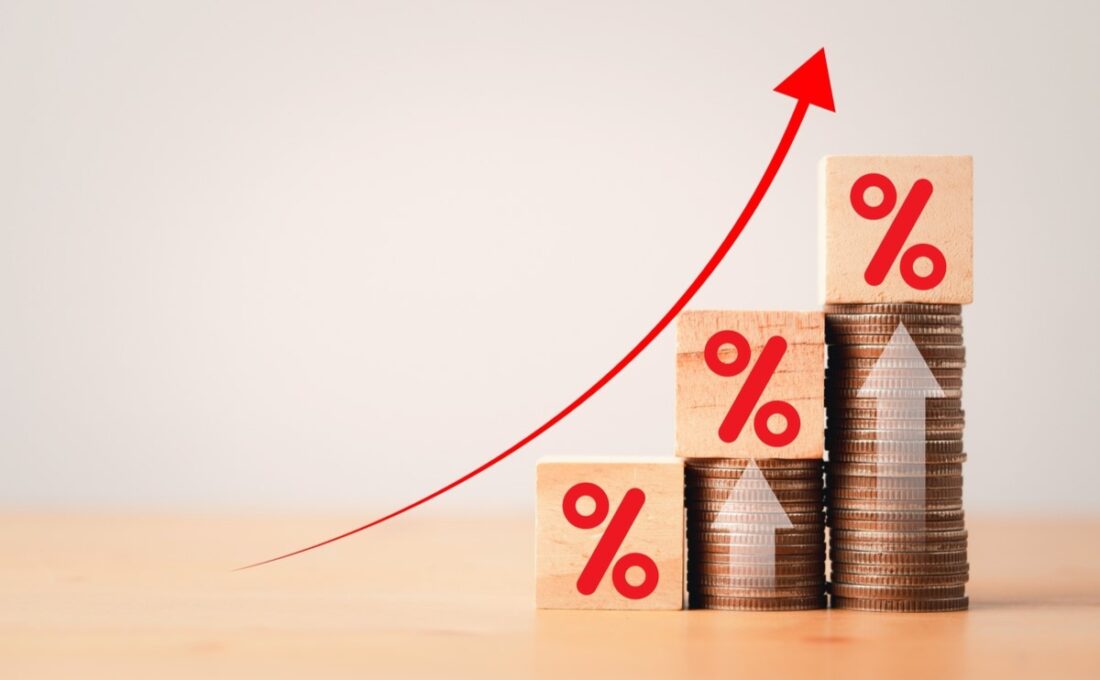 コインの上に積まれた木のブロックと上昇する矢印、投資利益の成長を表現。