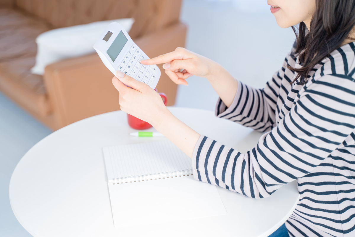 電卓を使って計算する女性