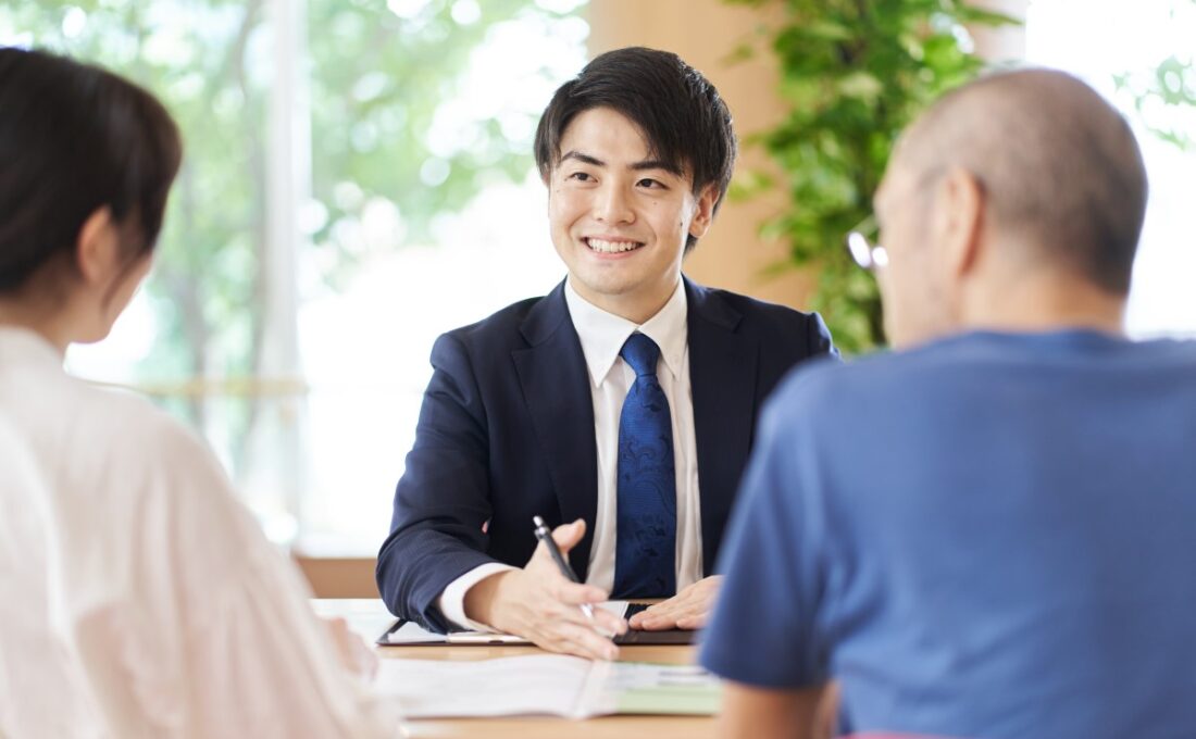 笑顔で相談に応じるスーツ姿の男性と顧客。