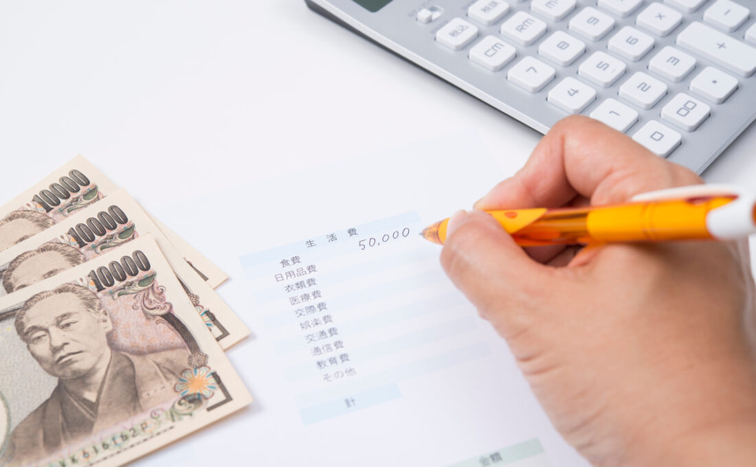 生活費を記入している紙、1万円札、電卓