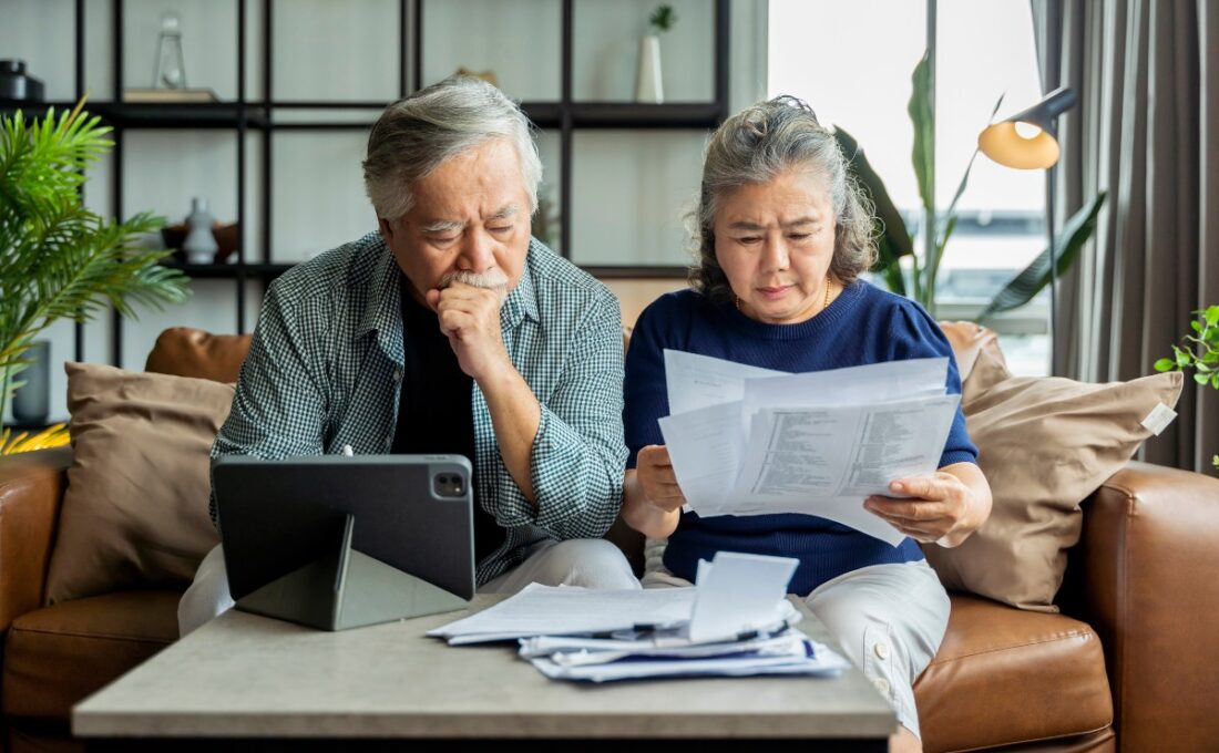 書類を見ながら話し合う年配の夫婦。