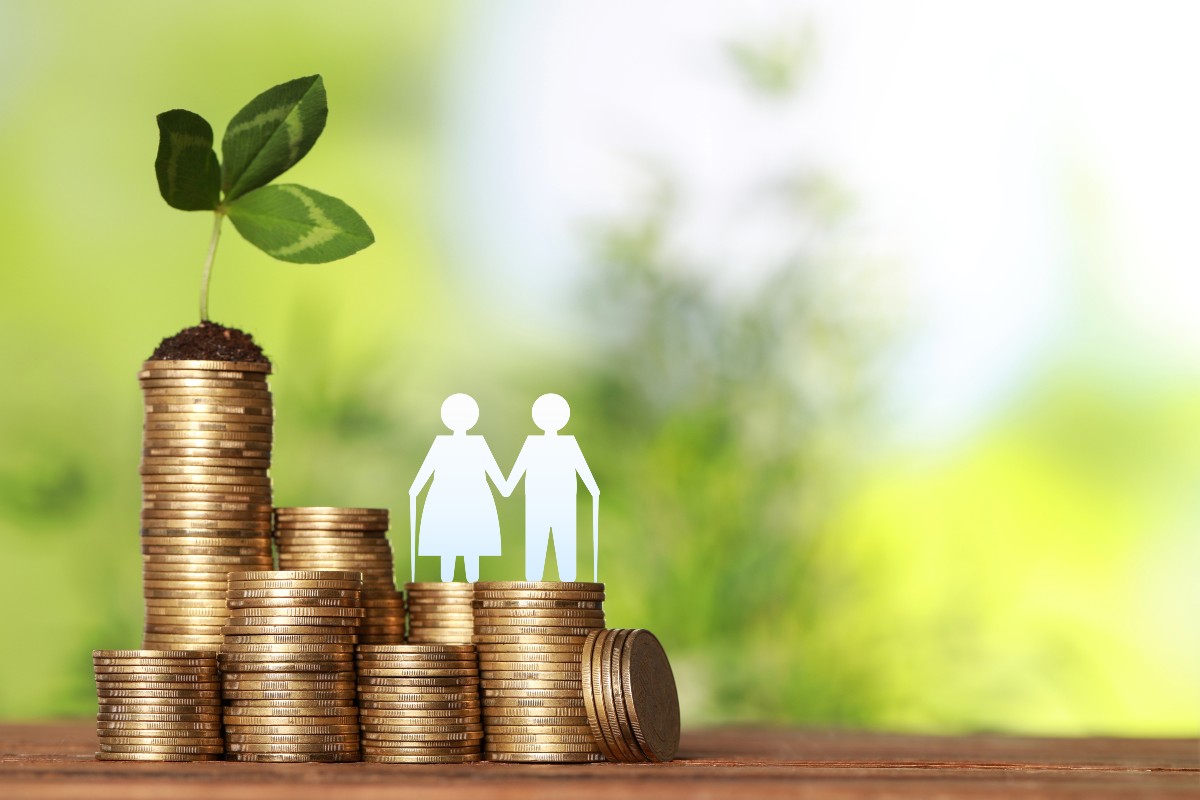 コインの山と年配のカップルのシルエット。