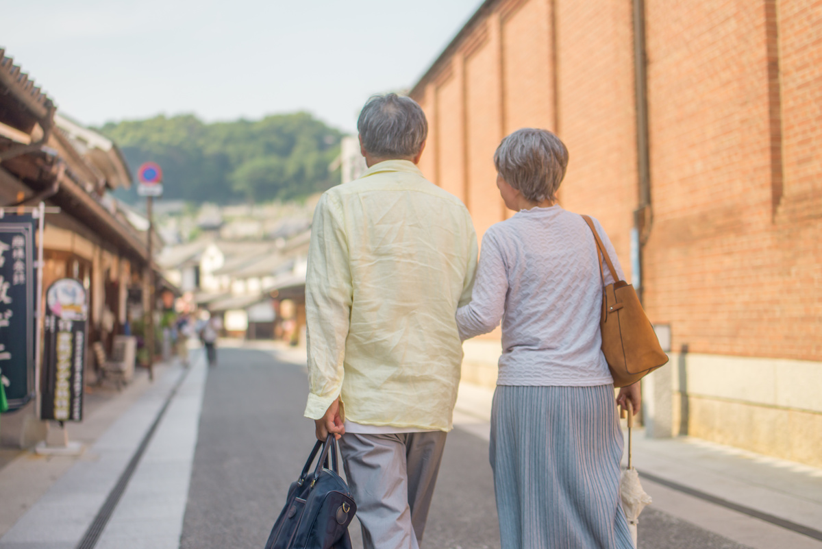 腕を組んで歩く年配の夫婦。