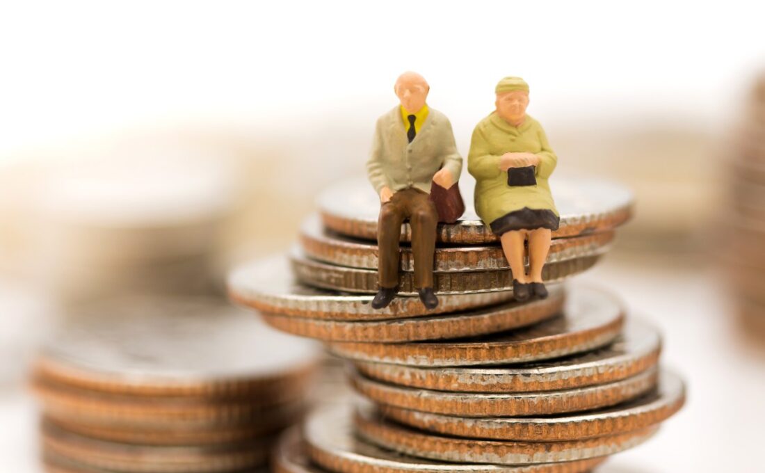 積み重なったコインの上に座っている老夫婦の人形