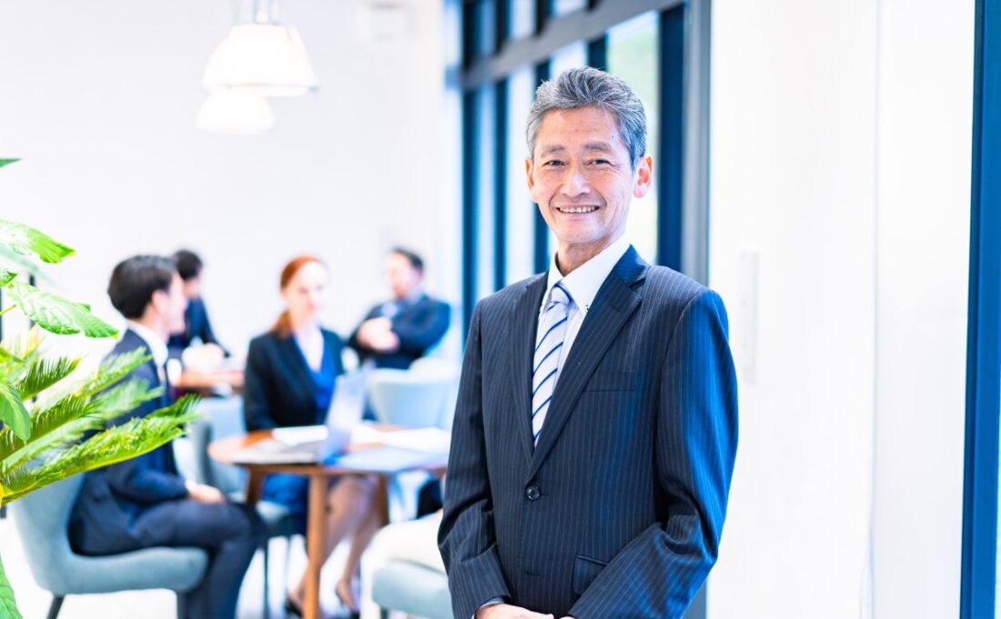 オフィスで微笑む60代ビジネスマン