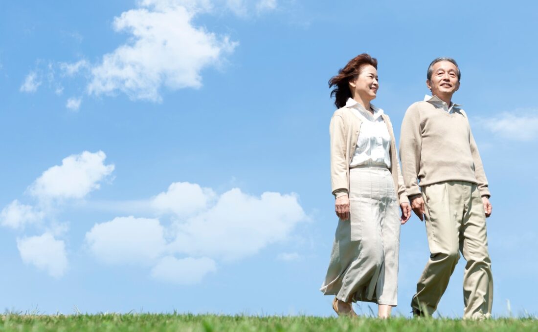 青空の下で散歩する中年の夫婦