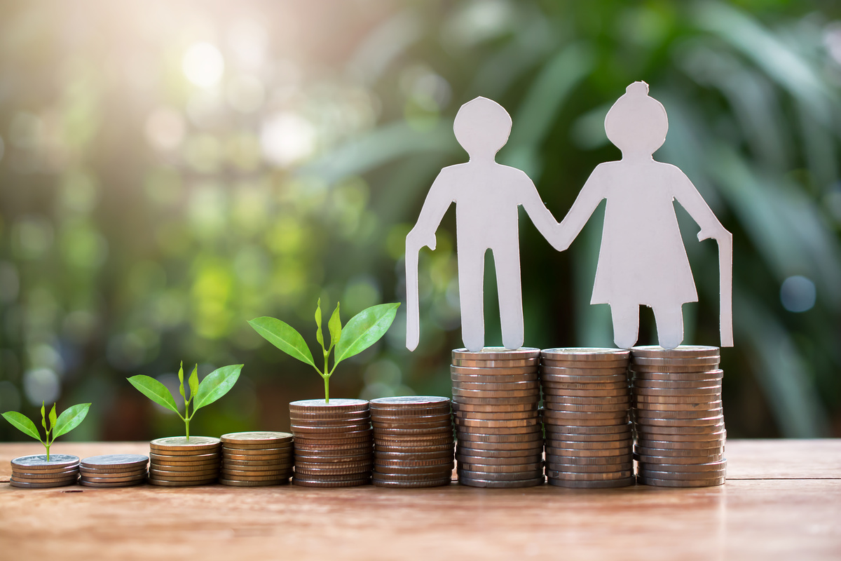 年金の貯蓄を象徴するコインとシルエットの夫婦