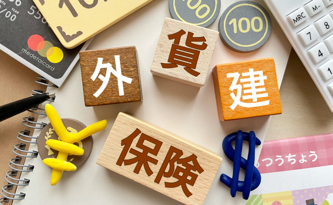 保険、外貨、建設などのキーワードが書かれたブロックと関連するアイテムが並べられたテーブル