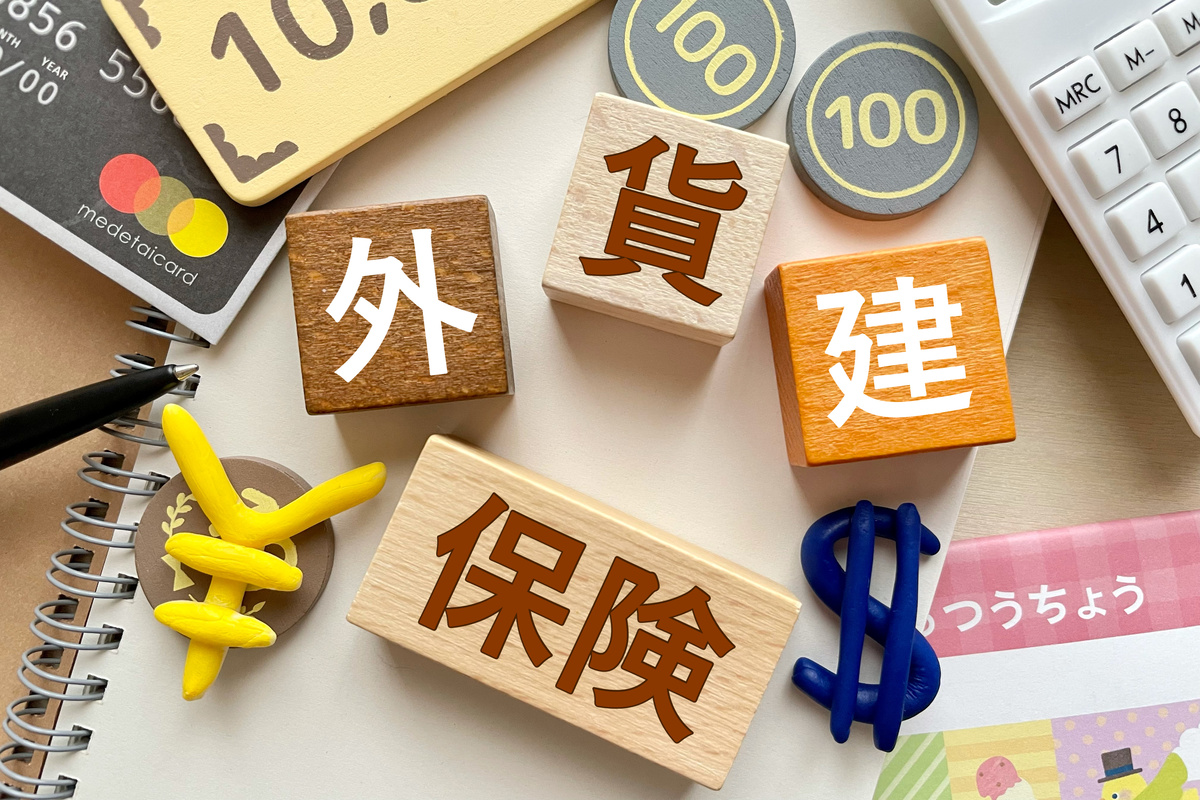 保険、外貨、建設などのキーワードが書かれたブロックと関連するアイテムが並べられたテーブル