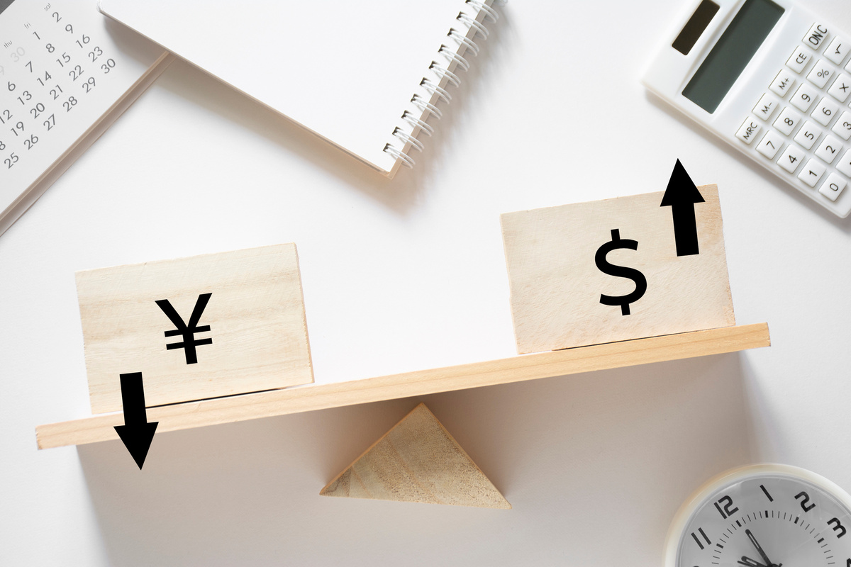天秤にかけられた円とドルのシンボル、ドルの価値が上昇している様子