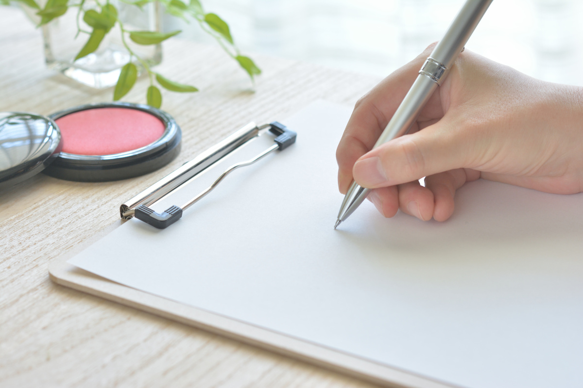 クリップボードにメモを取る手元