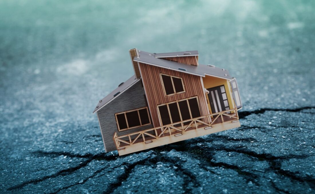 地震の影響で傾いた家の模型、ひび割れた地面