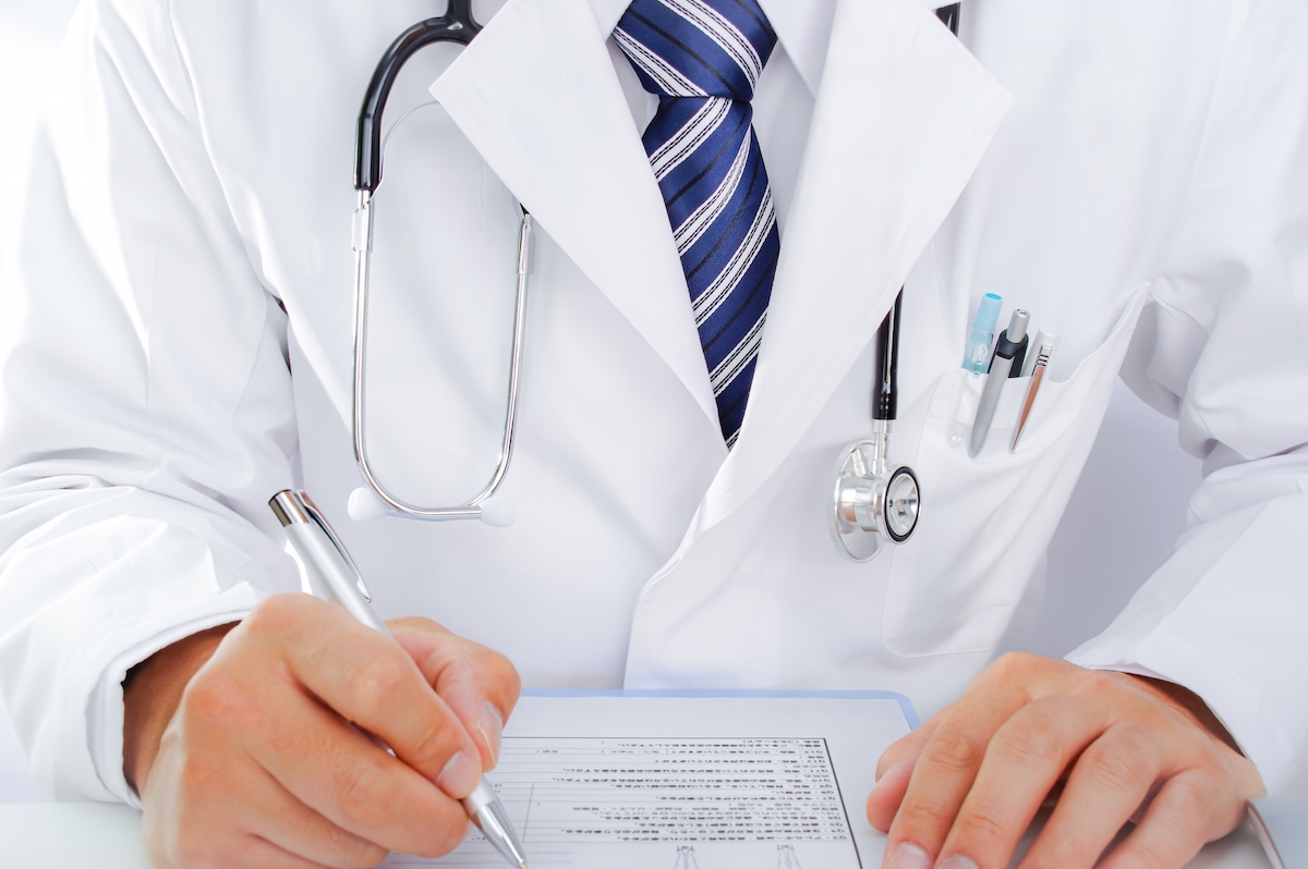 白衣を着た男性の手元