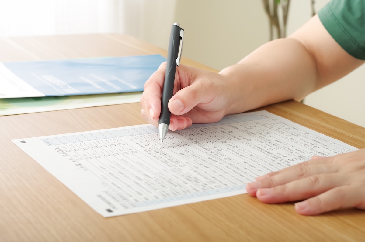 用紙を記入している手元の画像